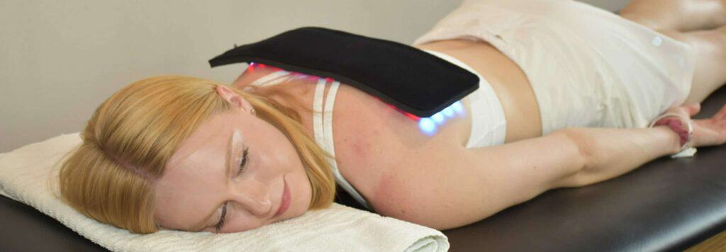 Girl using red light therapy for back pain